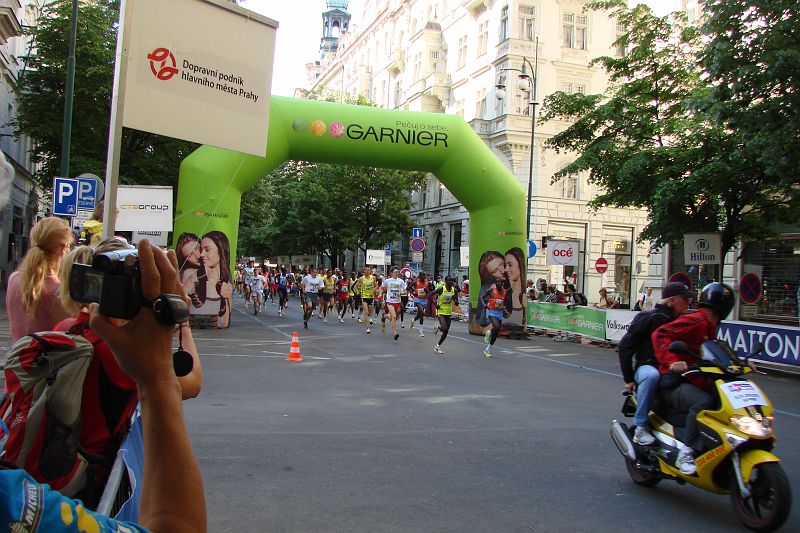 DSC04966.JPG - A už běží v čele tradičně Africké gazely. Jen nás zarazilo, že spolu s nimi běží i amatéři. Poslední dobou nejdřív odstartovali profesionálové a po několika sekundovém zpoždění pustili ostatní. No aspoň si amatéři užili pár sekund slávy, déle s Keňany vydržet běžet nejde.
