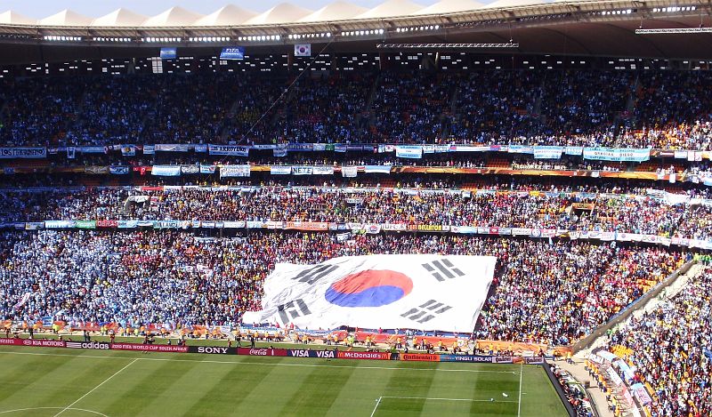 PC050846.JPG - Sektor Jižní Koreje. Škoda, že přes vuvuzely nebylo slyšet jejich fandění a hlavně pak hraní na jejich tradiční nástroje.