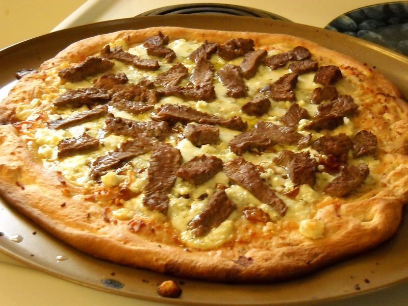 steakpizza.jpg - Vrchol hovězích orgií jsme ovšem zažili právě v Mossel Bay. I přes Krociho protesty, že pizzu moc nemusí, jsme na večeři zavítali do místní pizzerie. Samozřejmě, že první co nás bouchlo do očí byla steak&ribs pizza. Tato ilustrační fotografie je pouze slabí odvar, proti tomu co jsme dostali. Pizza byla tak pokrytá masem ze steaku a žebírek, že vůbec nebylo vidět těsto. Kroci ji ocenil titulem nejlepší pizza na světě.